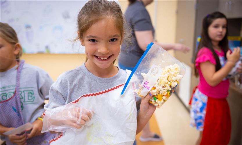 A girl wearing a grey shirt smiles